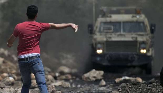 A Palestinian protester throws a rock towards Israeli security forces during clashes following a weekly demonstration against the expropriation of Palestinian land by Israel in the village of Kfar Qaddum, near Nablus in the occupied West Bank.