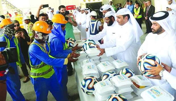 Kahramaa president Essa bin Hilal al-Kuwari and the Supreme Committee for Delivery & Legacy 2022, secretary general Hassan al-Thawadi presenting the workers with food packets and footballs. PICTURE: Noushad Thekkayil