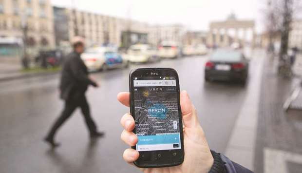 A smartphone displays the Uber Technologies app in this arranged photograph in Berlin. Overturning a lower court ruling, the 2nd US Circuit Court of Appeals in Manhattan said Uber and former chief executive officer Travis Kalanick properly notified customers in online user agreements that disputes should be arbitrated.