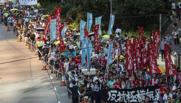 Protesters march in Hong Kong to protest the jailing of the leaders of Hong Kong's 'Umbrella Movemen