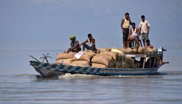 People transport sacks of rice on a boat in Morigaon district in Assam state on Sunday.