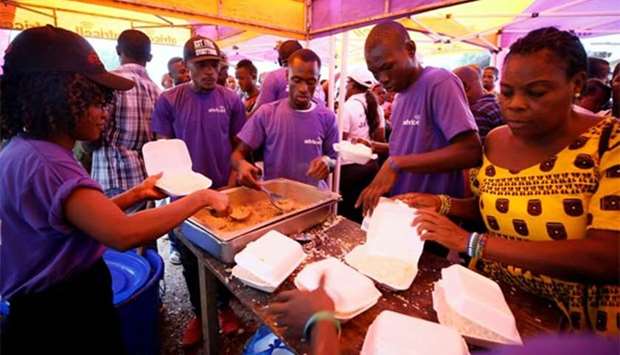 A non-governmental organisation serves meals to victims of the mudslide at the internally displaced persons camp in Regent, Sierra Leone on Saturday.