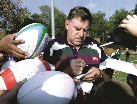 In this May 19, 1995, picture, New Zealandu2019s team manager Colin Meads signs autographs for school children as the All Blacks visit Wanderers Stadium in Johannesburg, South Africa, ahead of Rugby World Cup. (Reuters)