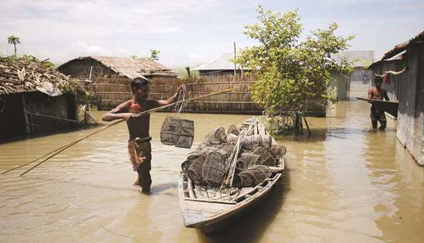 A fisherman prepares his fishing cages in his flooded village in Gaibandha, Bangladesh.