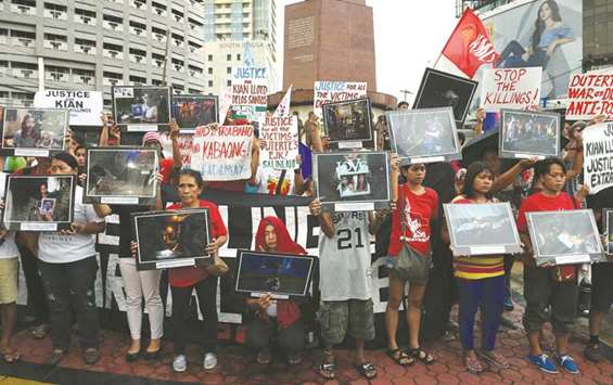 Relatives and supporters of victims of extra judicial killings, hold portraits of relatives allegedly killed during anti-drug raids by police, during a protest in Manila.