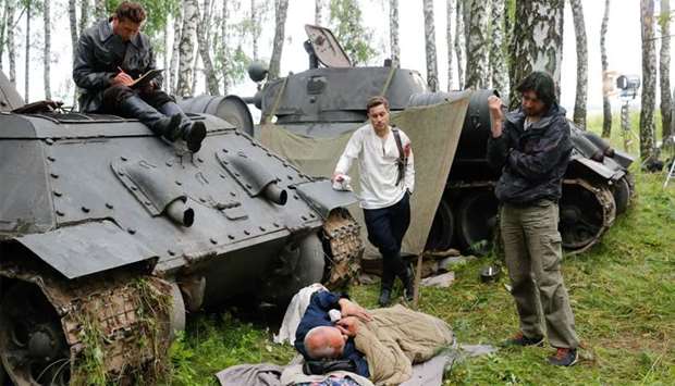 Russian director Kim Druzhinin (R) speaking with actors during the shooting of a scene of his movie - currently with the working title ,To See Stalin,