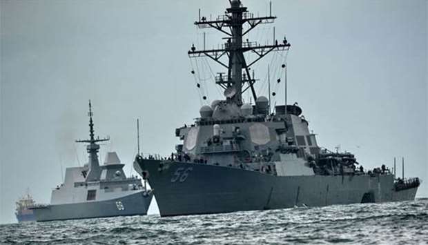 The USS John S. McCain (right), with a hole on its portside after a collision with an oil tanker, is escorted by Singapore Navy RSS Intrepid to Changi naval base in Singapore on Monday.