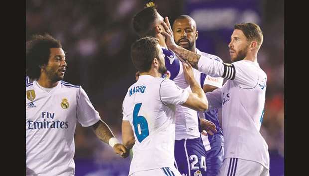 Real Madridu2019s defender Sergio Ramos (R) clashes with Deportivo La Corunau2019s Swiss defender Fabian Schar during their La Liga match.