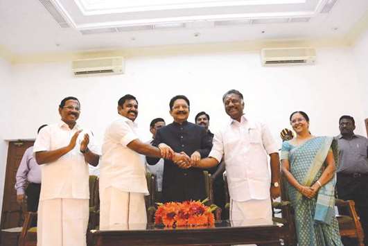 Tamil Nadu Chief Minister Edappadi K Palaniswami and O Panneerselvam shake hands in the presence of Governor Vidyasagar Rao at the swearing-in ceremony of Panneerselvam as the deputy chief minister, in Chennai yesterday.