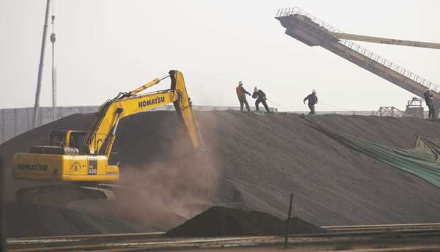 Labourers work on a pile of iron ore at a steel factory in China. Iron ore is expected to hold above $70 a metric tonne right through to the end of December after rallying on Chinese demand, according to RBC Capital Markets.
