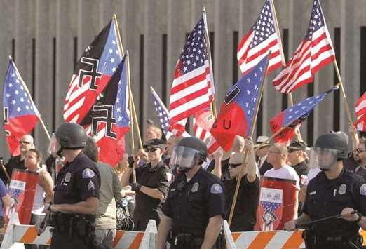 Members of the National Socialist Movement hold flags and shields donning swastikas during a rally outside Pomona City Hall in November 2011.
