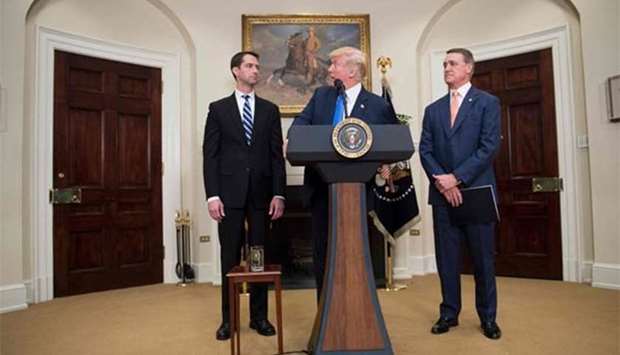 President Donald Trump makes an announcement on immigration with Senators Tom Cotton (left) and David Perdue at the White House in Washington, DC, on Wednesday.