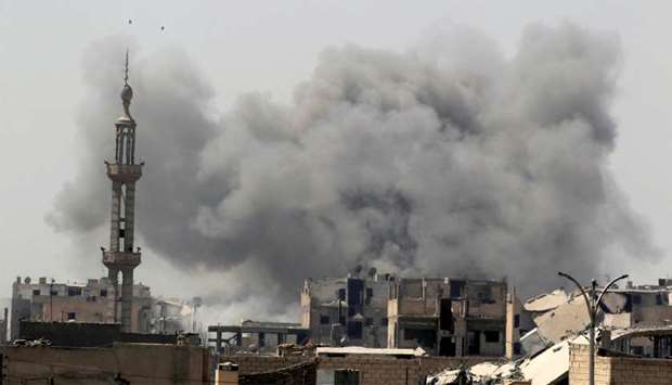 Smoke rises after an air strike  in Raqqa