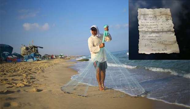 Palestinian fisherman Jihad al-Soltan prepares to throw his fishing net on a beach in Beit Lahia in the northern Gaza Strip on Tuesday.  Inset, the message the fisherman found in a bottle off a Gaza beach.