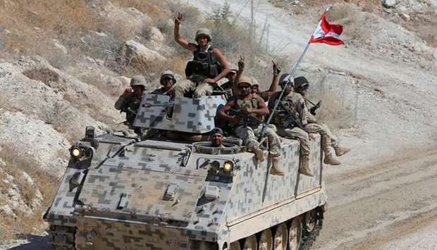 Lebanese army soldiers are seen flashing victory signs in the town of Ras Baalbek, Lebanon, yesterday. Reuters