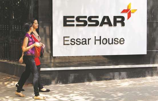 Employees walk past an Essar Group logo outside its headquarters in Mumbai. A tribunal in Indiau2019s Gujarat state agreed to start insolvency proceedings against the debt-laden mill owned by the billionaire Ruia brothers, according to sources.