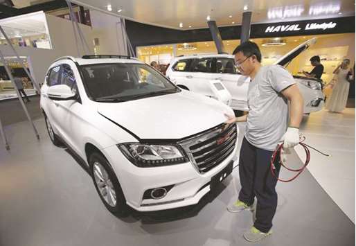 A staff member checks a Haval H2 from Great Wall Motors during the Auto China 2016 auto show in Beijing (file). Great Wall may find it tough to obtain Chinese regulatory approval for a deal with Fiat Chrysler due to recent restrictions on capital outflow, sources said.