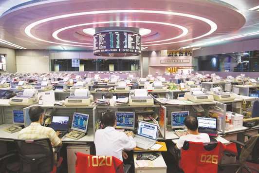 Traders work at the Hong Kong Stock Exchange. The Hang Seng closed up 0.9% to 27,401.67 points yesterday.