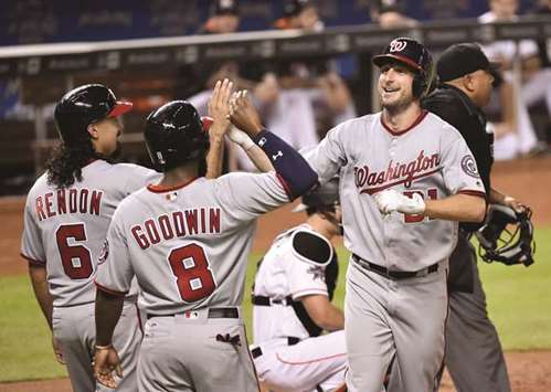 Washington Nationals starting pitcher Max Scherzer (right) is greeted by teammates Brian Goodwin and Anthony Rendon after hitting a three run home run in the second inning against the Miami Marlins at Marlins Park in Miami on Tuesday. (USA TODAY Sports)