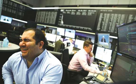 Traders work at the Frankfurt Stock Exchange. The DAX 30 closed up 1.4% to 12,229.34 points yesterday.
