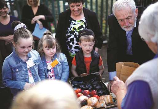 This picture taken on August 17 shows Corbyn helping to fill childrenu2019s packed lunches outside the Hope Centre in Bolton.