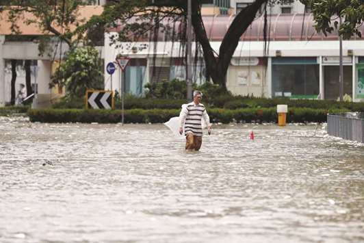 A man walks through a flooded street as Typhoon Hato hits Hong Kong.