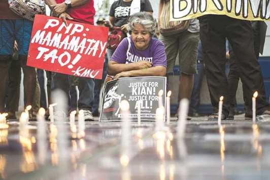 An activist holds a poster against extra-judicial killings during a protest in Manila.
