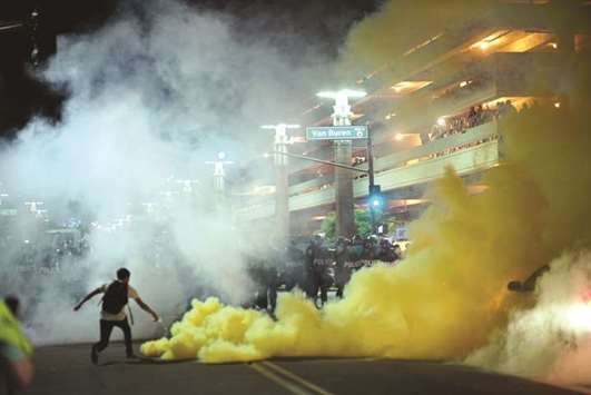 Police officials lob tear gas to try and disperse demonstrators after a Donald Trump campaign rally in Phoenix, Arizona.