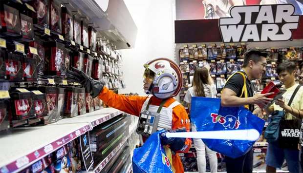 A fan dressed up as Luke Skywalker picks Star Wars toys