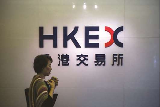A pedestrian walks past a signage of the Hong Stock Exchange. The bourse rose 0.4% to 27,518.60 yesterday, a third successive gain as traders returned to work after Wednesdayu2019s typhoon.