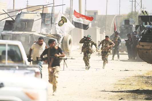 Members of the Iraqi forces advance through Tal Afaru2019s Al Wahda district yesterday.