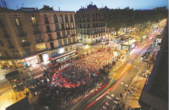 People gather at a memorial where a van crashed into pedestrians, at Las Ramblas in Barcelona.