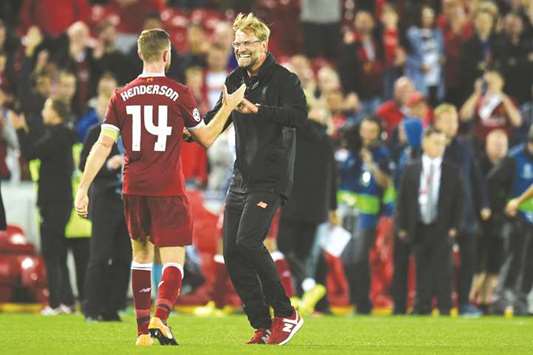Liverpoolu2019s German manager Jurgen Klopp (right) celebrates with captain Jordan Henderson after their Champions League play-off win over Hoffenheim at Anfield stadium in Liverpool on Wednesday night. (AFP)