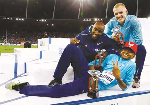 Qatar Mutaz Essa Barshim (foreground), Britainu2019s Mo Farah (left) and Sam Kendricks of the US pose with their Diamond League Trophies in Zuirch yesterday. (Reuters)