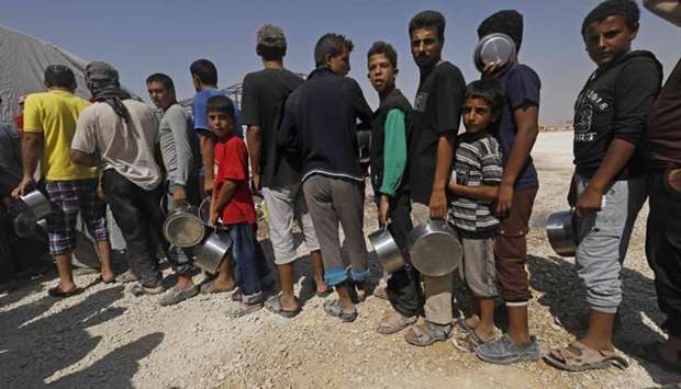 Displaced Syrians queue up to receive food at the Al-Mabrouka camp in the village of Ras al-Ain on the Syria-Turkey border, where many Syrians who fled from territory held by the Islamic State (IS) group in Raqa and Deir Ezzor are taking shelter