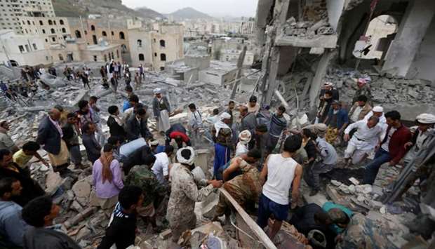 People search under rubble of a house destroyed by a Saudi-led air strike in Sanaa, Yemen