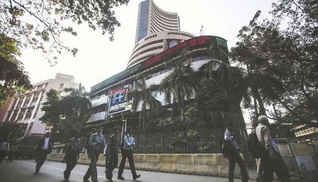 People walk by the Bombay Stock Exchange building in Mumbai. Local investors pouring money into Asiau2019s second-best performing equity market this year may turn to bonds u2013 or even gold u2013 if the Reserve Bank of India delays further reduction in borrowing costs, according to Auerbach Grayson and Co.