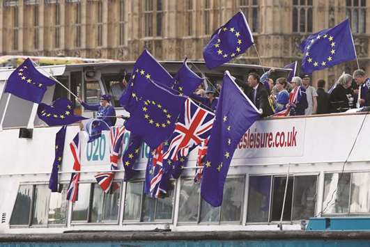 This picture taken on August 19 shows anti-Brexit, pro-EU supporters wave flags as they travel up and down the River Thames, outside the Houses of Parliament, in London.