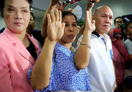 Saldy and Lorenza Delos Santos, parents of 17-year-old high school student Kian Delos Santos take oath as they file murder charges against three anti-narcotics policemen at the Department of Justice in metro Manila.