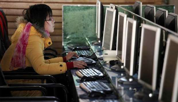 A woman uses a computer in an internet cafe at the centre of Shanghai