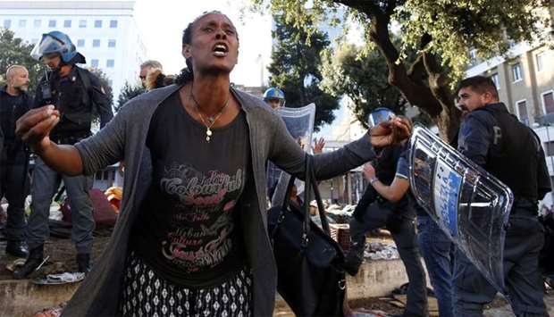 A refugee protests in the street after being removed by police officers from a small square that had been occupied by refugee squatters, in central Rome