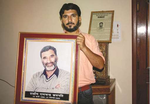 Journalist Anshul Chhatrapati shows a portrait of his father Ram Chander Chhatrapati, who controversial religious leader Ram Rahim Singh is accused of killing in 2002, in Sirsa.