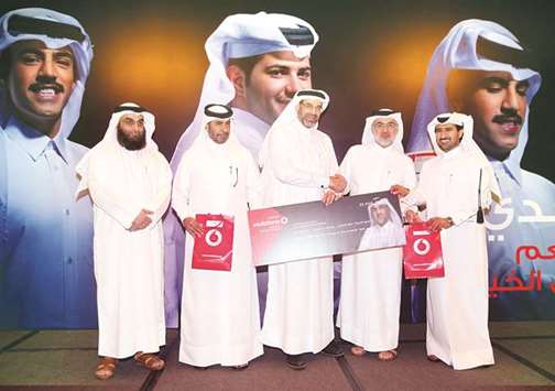 Vodafone Qataru2019s Mohamed al-Yami presents a cheque to senior representatives from the three beneficiary charities.