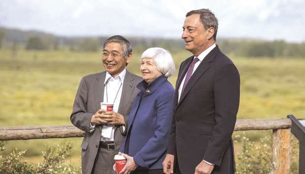 BoJ governor Haruhiko Kuroda, Fed chair Janet Yellen and ECB president Mario Draghi pose for photographs while walking the grounds at the Jackson Hole economic symposium in Moran, Wyoming. Yellen distanced herself on Friday from the  anti-regulatory rhetoric of the man who will decide whether to replace her, President Donald Trump.