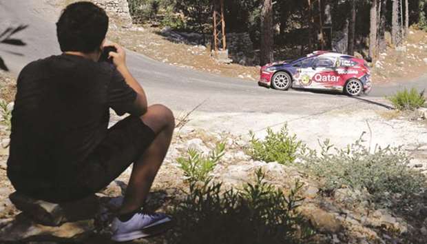 A fan watches as Qataru2019s Nasser al-Attiyah and Mathieu Baumel take part in the Rally of Lebanon near the northern Lebanese village of Sourat yesterday. Al-attiyah, however, crashed out of the rally.