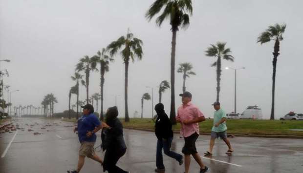 A group of people race across the street as winds from Hurricane Harvey escalated in Corpus Christi, Texas