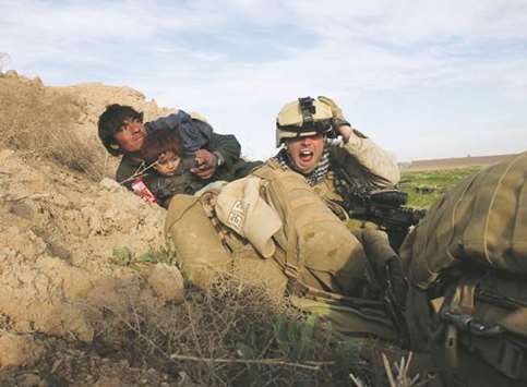 US Marine Lance Corporal Chris Sanderson, 24, from Flemington, New Jersey, shouts as he tries to protect an Afghan man and his child after Taliban fighters opened fire in the town of Marjah, in Nad Ali district, Helmand province, February 13, 2010.