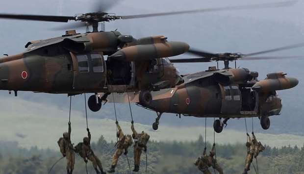 Japanese Ground Self-Defense Force soldiers rappel from UH-60 Black Hawk helicopters during an annual training session near Mount Fuji at Higashifuji training field in Gotemba, west of Tokyo, Japan August 24, 2017.