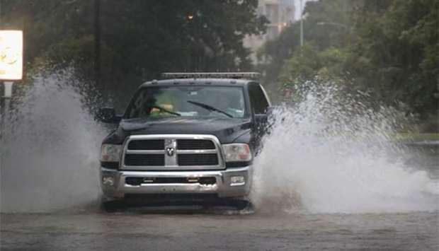 A truck navigates a street which has been inundated with flooding from Hurricane Harvey in Houston, Texas on Sunday.