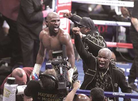 Floyd Mayweather Jr. (left) and his father celebrate the 10th round technical knockout victory over Conor McGregor at the T-Mobile Arena in Las Vegas, Nevada, on Saturday. (AFP)